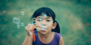 girl blowing bubbles summertime activities