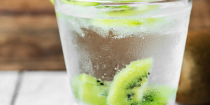 short glass with water and slices of kiwi