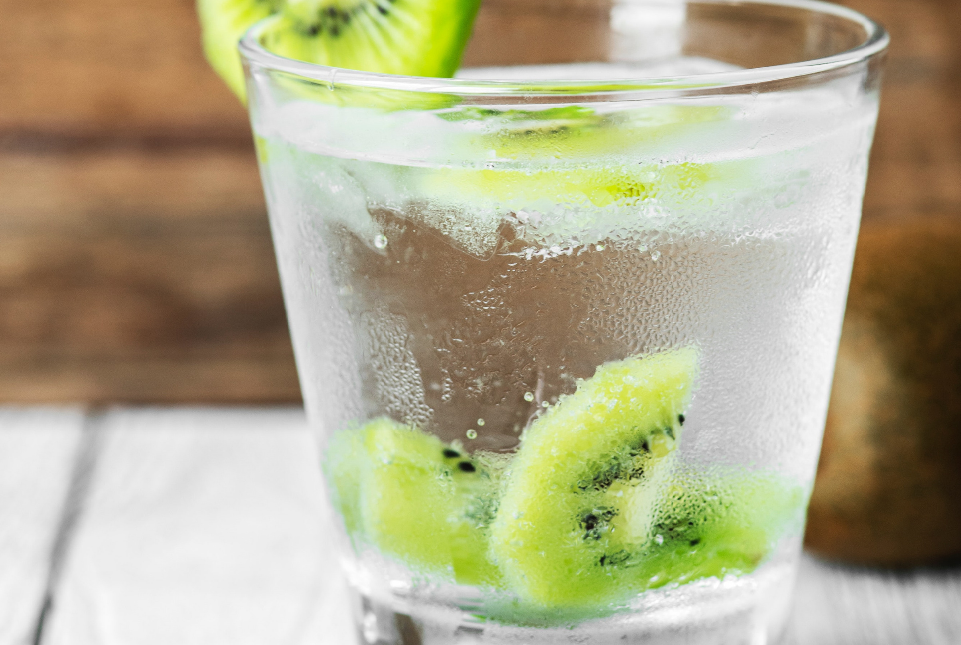 short glass with water and slices of kiwi