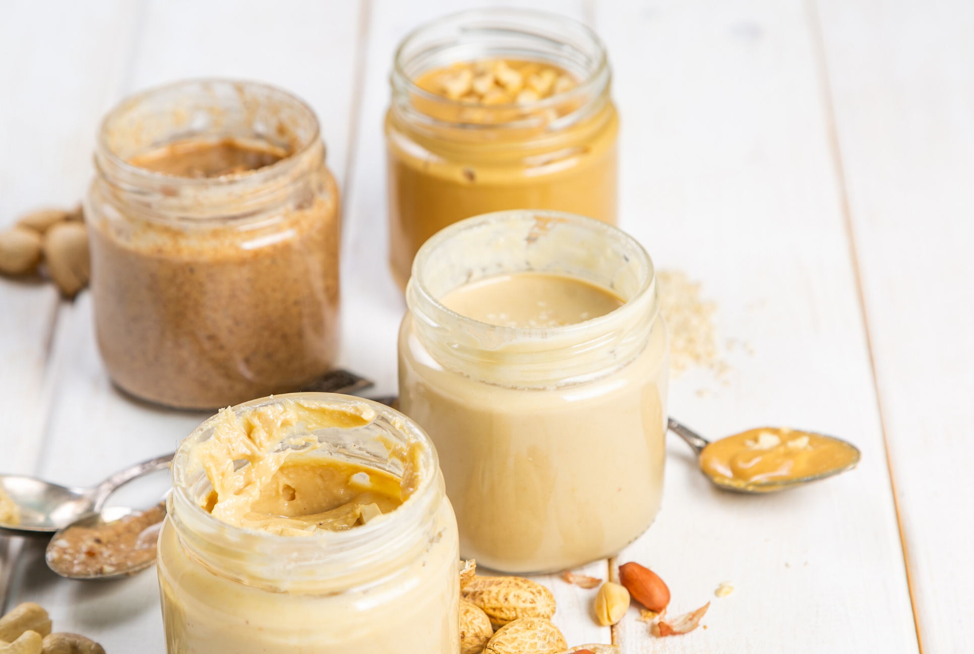 four jars of nut butters and spoon