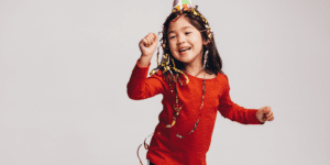 girl in red shirt and party hat dancing