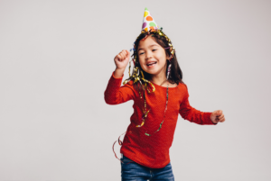 girl in red shirt and party hat dancing