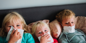 three young kids in bed with runny noses immunity boosters