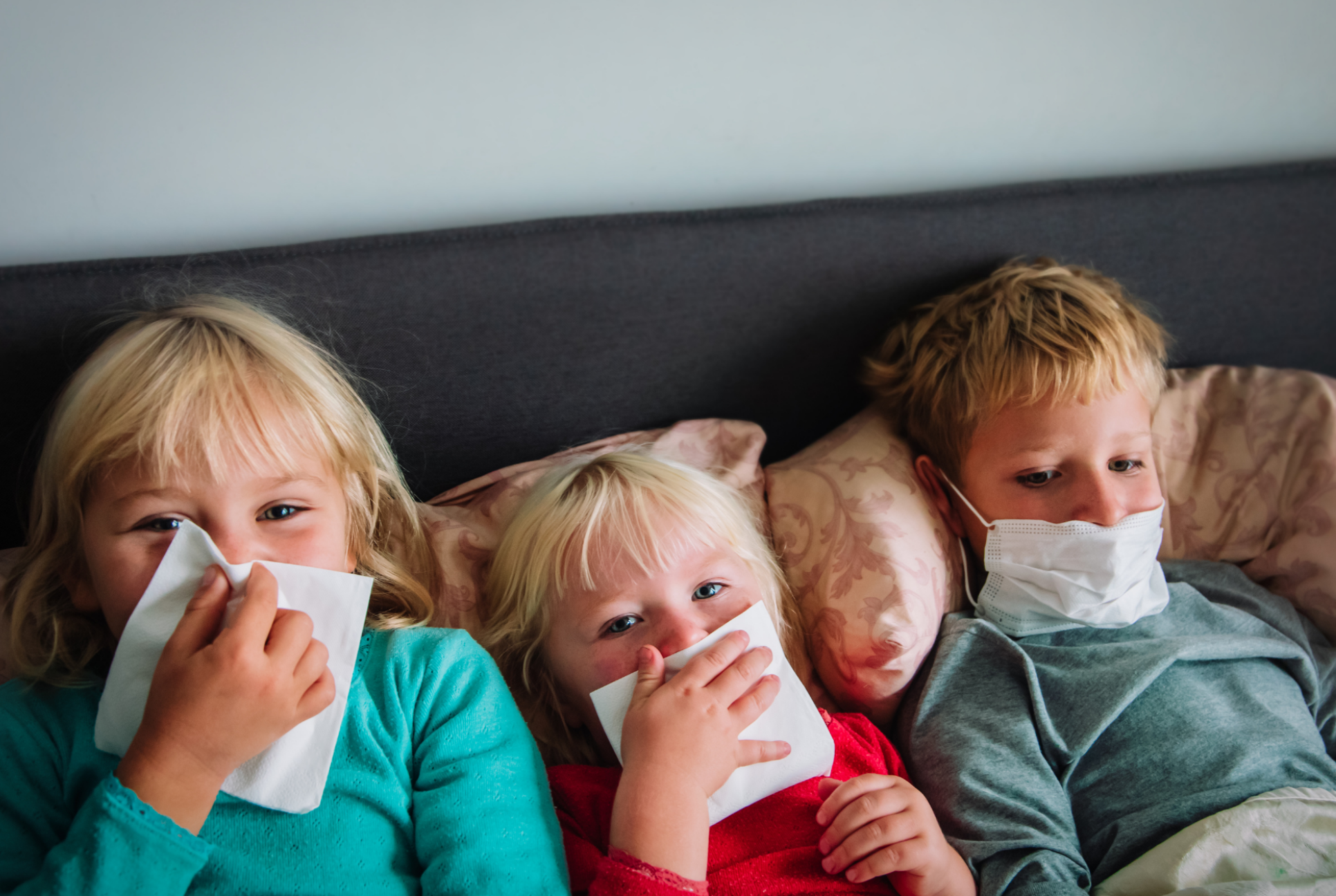 three young kids in bed with runny noses immunity boosters