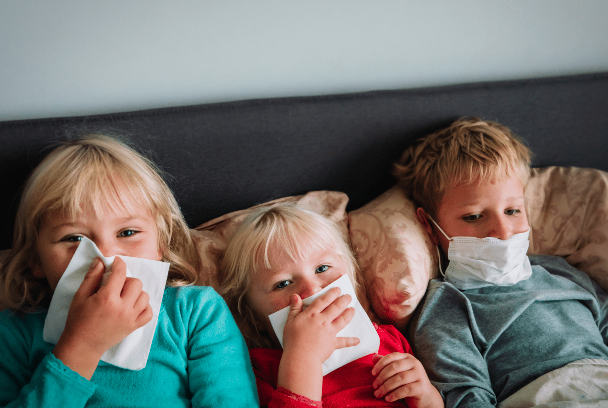 three young kids in bed with runny noses immunity boosters