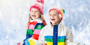 a boy and girl play in the snow